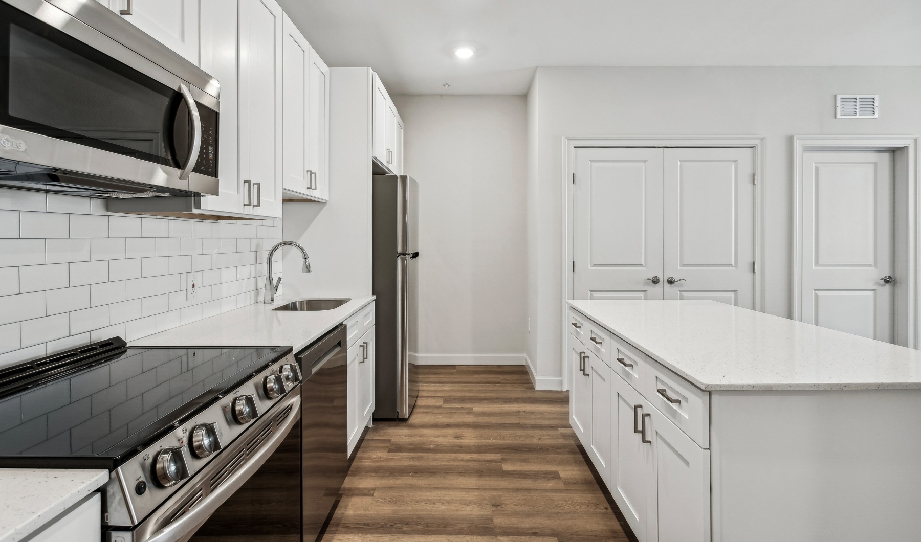 kitchen with stainless steel appliances and white counters and cabinets