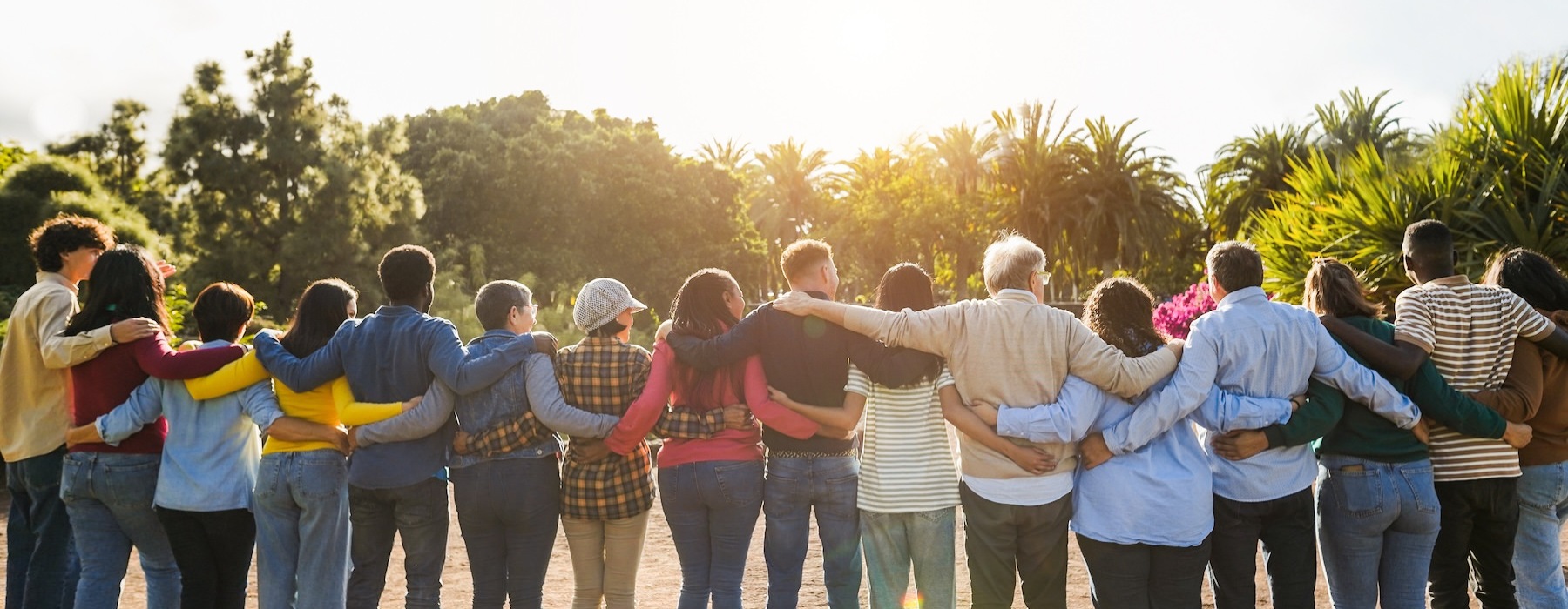 a group of people embracing looking at a sunset